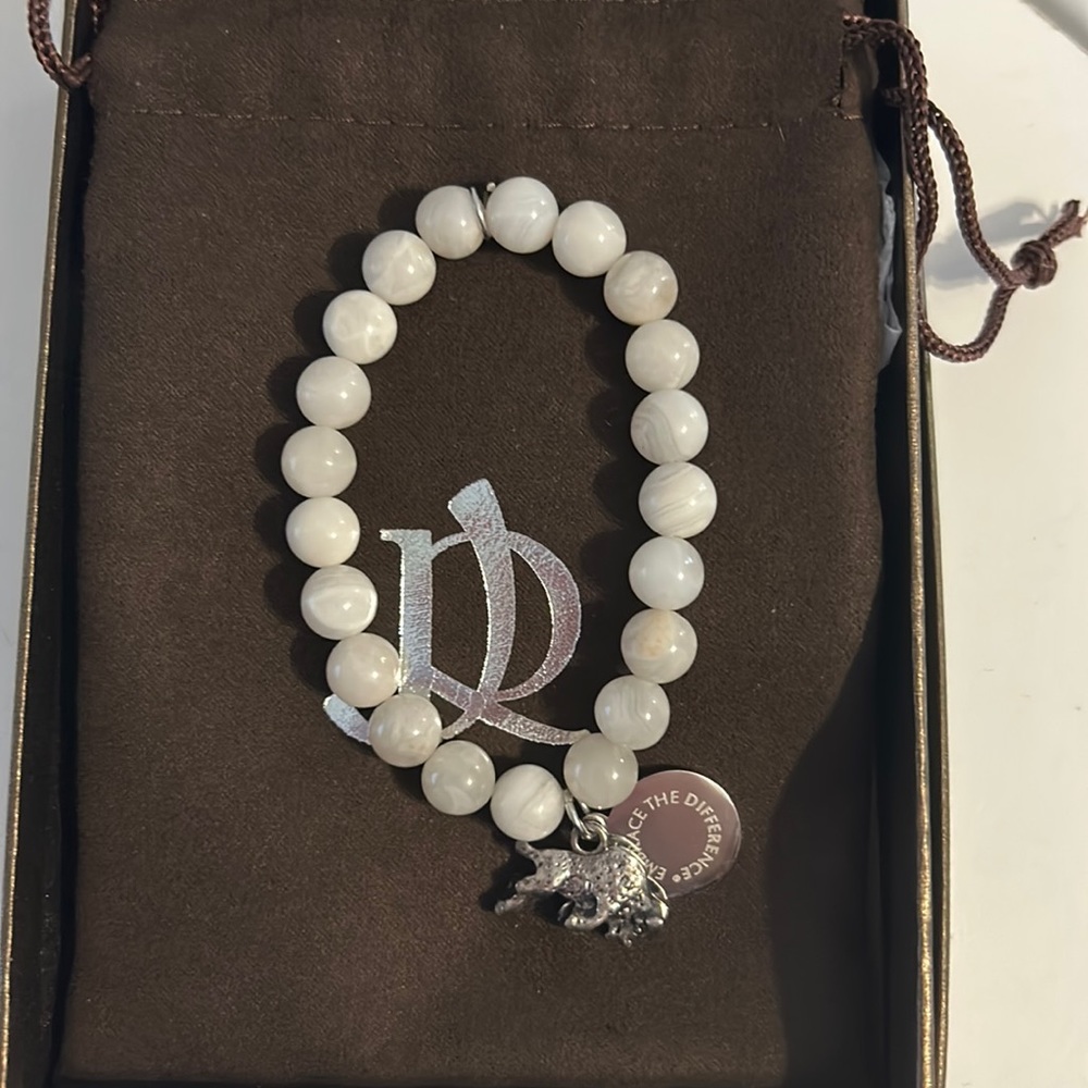 Beautiful pearly/marbled white beaded bracelet with a Buffalo charm.